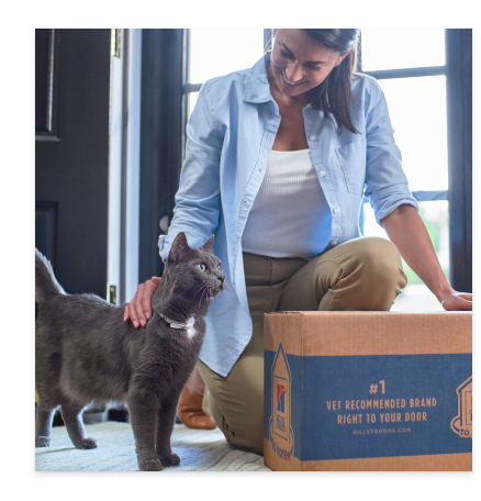 ผู้หญิงคนหนึ่งกับแมวขนสีดำของเธอและบรรจุภัณฑ์อาหารแมว Hill's Pet